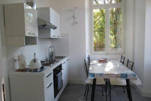 una cucina con tavolo, lavandino e finestra di Villa Peachey, Intero piano con giardino a Stresa