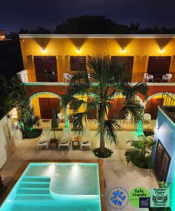 a swimming pool in front of a house with a palm tree at Merida Santiago Hotel Boutique in Mérida