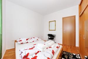 a bedroom with a bed with red and white pillows at Apartment Village Nin in Nin