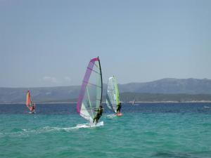 three people windsurfing in the water on the ocean at Villa Jasmin in Bol