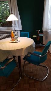 a table with two blue chairs and a lamp at Stadtnahe Wohnung mit Garten und Parkplatz in Oldenburg