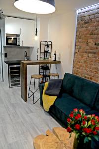 a living room with a couch and a kitchen at LOFT MAŁY in Kościerzyna