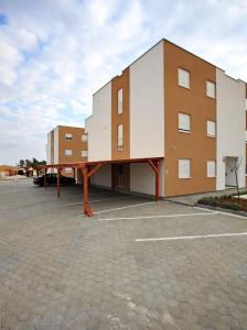 a large building in a parking lot at Apartment Village Nin in Nin