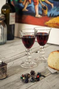 due bicchieri di vino rosso seduti su un tavolo di Stabilimento Wine & Design Apartment a Campi Salentina