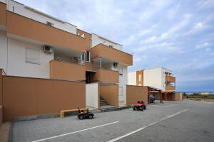 a building with two mobility scooters parked in a parking lot at Apartment Village Nin in Nin