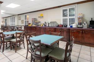 a restaurant with tables and chairs and a kitchen at Days Inn by Wyndham Natchez in Natchez