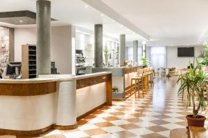 - un hall doté d'un bar avec des chaises et des tables dans l'établissement Club Hotel e Residence La Vela, à Nago-Torbole