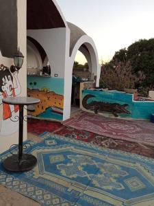 um quarto com piso em mosaico, uma mesa e um tapete em El Prince Guesthouse em Aswan