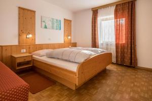 a bedroom with a large wooden bed and a window at Apartment Pustertal in Mühlbach