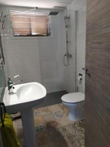 een badkamer met een witte wastafel en een toilet bij Dafne's Beach in La Pineda