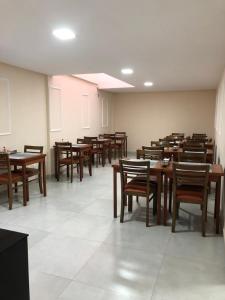 a dining room with wooden tables and chairs at Pousada Dubai in Itabuna