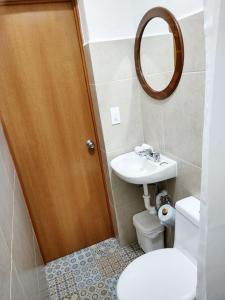 a bathroom with a sink and a toilet and a mirror at Hotel Puerto Caracol in Puerto Morelos