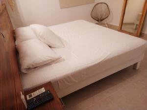 a bed with white sheets and pillows next to a desk at Hotel Puerto Caracol in Puerto Morelos