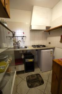una pequeña cocina con fregadero y nevera. en For Ever Apartments, en Fiumicino