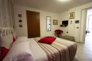 Un dormitorio con una cama con almohadas rojas. en For Ever Apartments, en Fiumicino