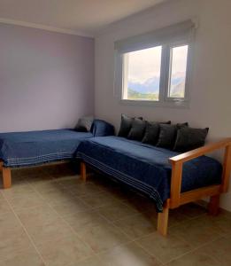 a room with two beds and a window at Polo Aparts in El Chalten