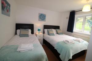 a bedroom with two beds with towels on them at Bolsover House in Bolsover