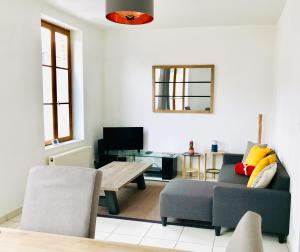 a living room with a couch and a table at Le 61 bis in Saint-Valéry-sur-Somme