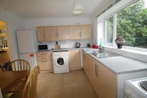 a kitchen with a washing machine and a window at Bolsover House in Bolsover