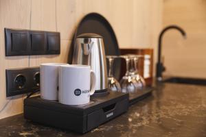 two white coffee mugs sitting on a counter at Kääriku ÖÖD HÖTELS in Kääriku