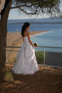 a woman in a wedding dress standing next to a beach at Villa Jasmin in Bol