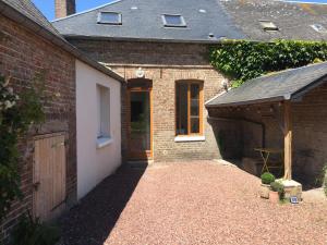 a brick house with a garage and a wooden door at Le 61 bis in Saint-Valéry-sur-Somme