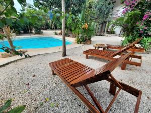 two wooden benches sitting next to a swimming pool at Aldea Balam in Tulum