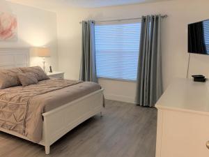 1 dormitorio con cama y ventana grande en CozyKey Vacation Rentals, en Kissimmee