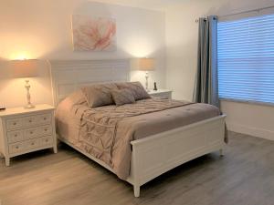 um quarto branco com uma cama e duas mesas de cabeceira em CozyKey Vacation Rentals em Kissimmee