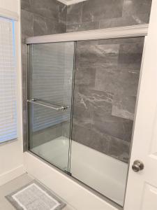 y baño con ducha y puerta de cristal. en CozyKey Vacation Rentals, en Kissimmee