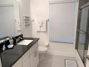 y baño con aseo, lavabo y ducha. en CozyKey Vacation Rentals, en Kissimmee