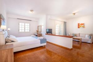 een woonkamer met een bed en een bank bij CORFU PELAGOS HOTEL in Moraitika
