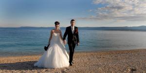 a bride and groom walking on the beach at Villa Jasmin in Bol