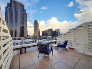 balcón con mesa, sillas y vistas a la ciudad en NOPSI Hotel New Orleans, en Nueva Orleans