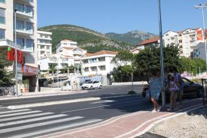 un grupo de personas esperando para cruzar la calle en un cruce en Apartments Bečić, en Budva