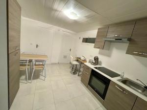 a kitchen with a table and a dining room at Appartement dans maison à Corbelin proche Walibi in Corbelin