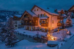 Una casa en la nieve por la noche en Dolomites Apartments Ciasa Vally, en San Cassiano