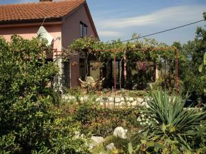 a house with a garden in front of it at Apartmani Mediteran in Vrh