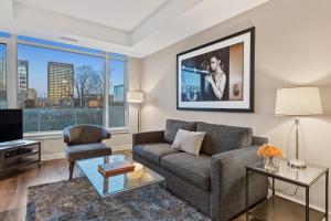 a living room with a couch and a tv at SOHO Residences Champagne in Ottawa