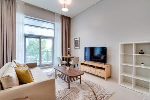 a living room with a couch and a tv at OSKENA Vacation Homes -The Lofts Boulevard Downtown in Dubai