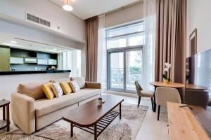 a living room with a couch and a table at OSKENA Vacation Homes -The Lofts Boulevard Downtown in Dubai