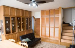 a living room with a black couch and wooden cabinets at STAY IN TOKIWA - Vacation STAY 16336v in Asahikawa