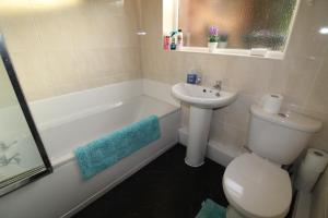 a bathroom with a sink and a toilet and a bath tub at Loscoe House in Codnor