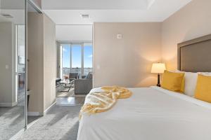 um quarto com uma grande cama branca com almofadas amarelas em SOHO Residences Lisgar em Ottawa