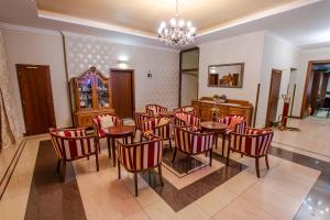 uma sala de jantar com cadeiras e mesas vermelhas e um lustre em Hotel Giovanni Giacomo em Teplice