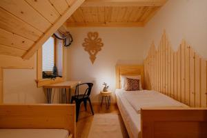 a bedroom with two beds and a desk in a room at Eco dom z sauną- Pasja II View,Lake & Ski in Kluszkowce