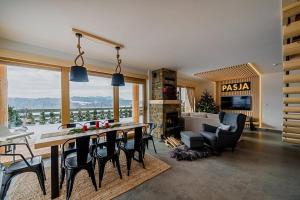 a kitchen and living room with a table and chairs at Eco dom z sauną- Pasja II in Kluszkowce