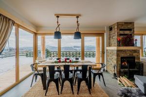 a dining room with a table and a fireplace at Eco dom z sauną- Pasja II View,Lake & Ski in Kluszkowce