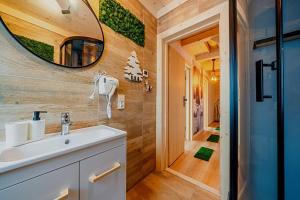 a bathroom with a sink and a mirror at Eco dom z sauną- Pasja II View,Lake & Ski in Kluszkowce +43 photos