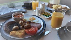 a table with a plate of breakfast foods and drinks at Bluebird Lodge in Coniston